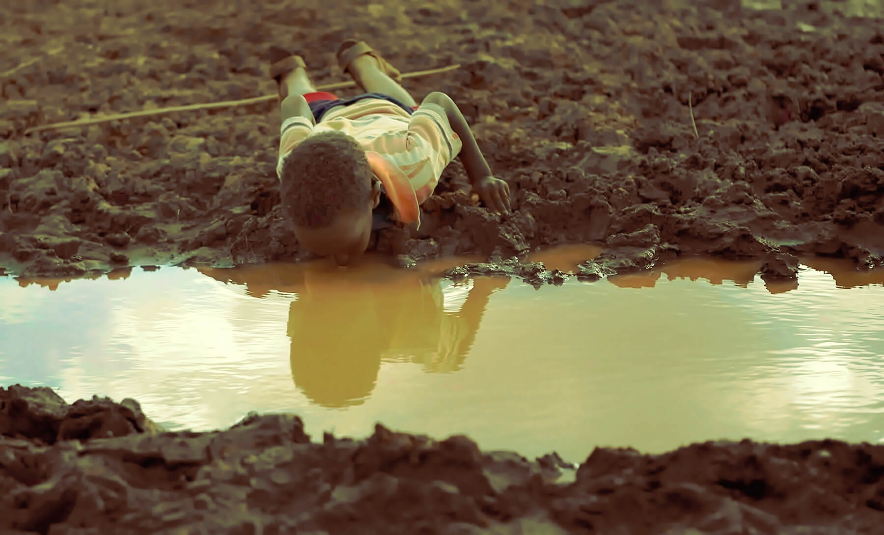 A boy drinks water from a pond in Bule Duba village in the outskirts of Moyale, near the edge of Oroma and Somali regions of Ethiopia, June 12, 2009. Copyright REUTERS/Irada Humbatova